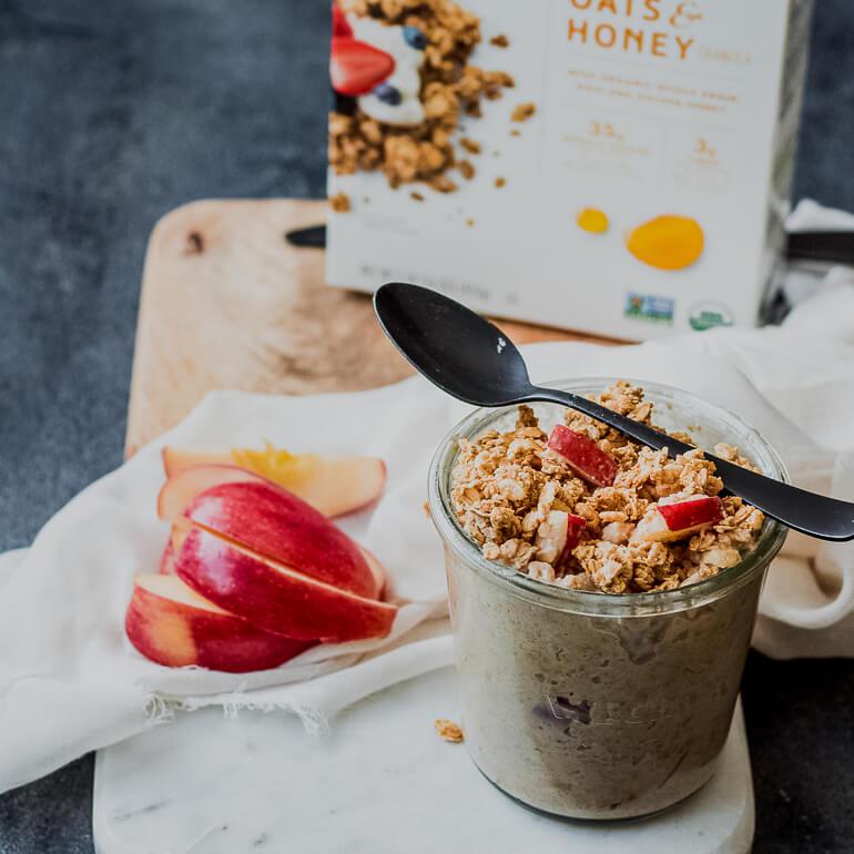 Recipe image of Cascadian Farm apple cinnamon overnight oats in a jar with a plate of sliced apples on the side